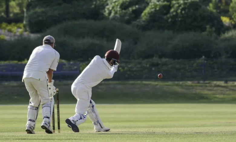 a person in white playing cricket